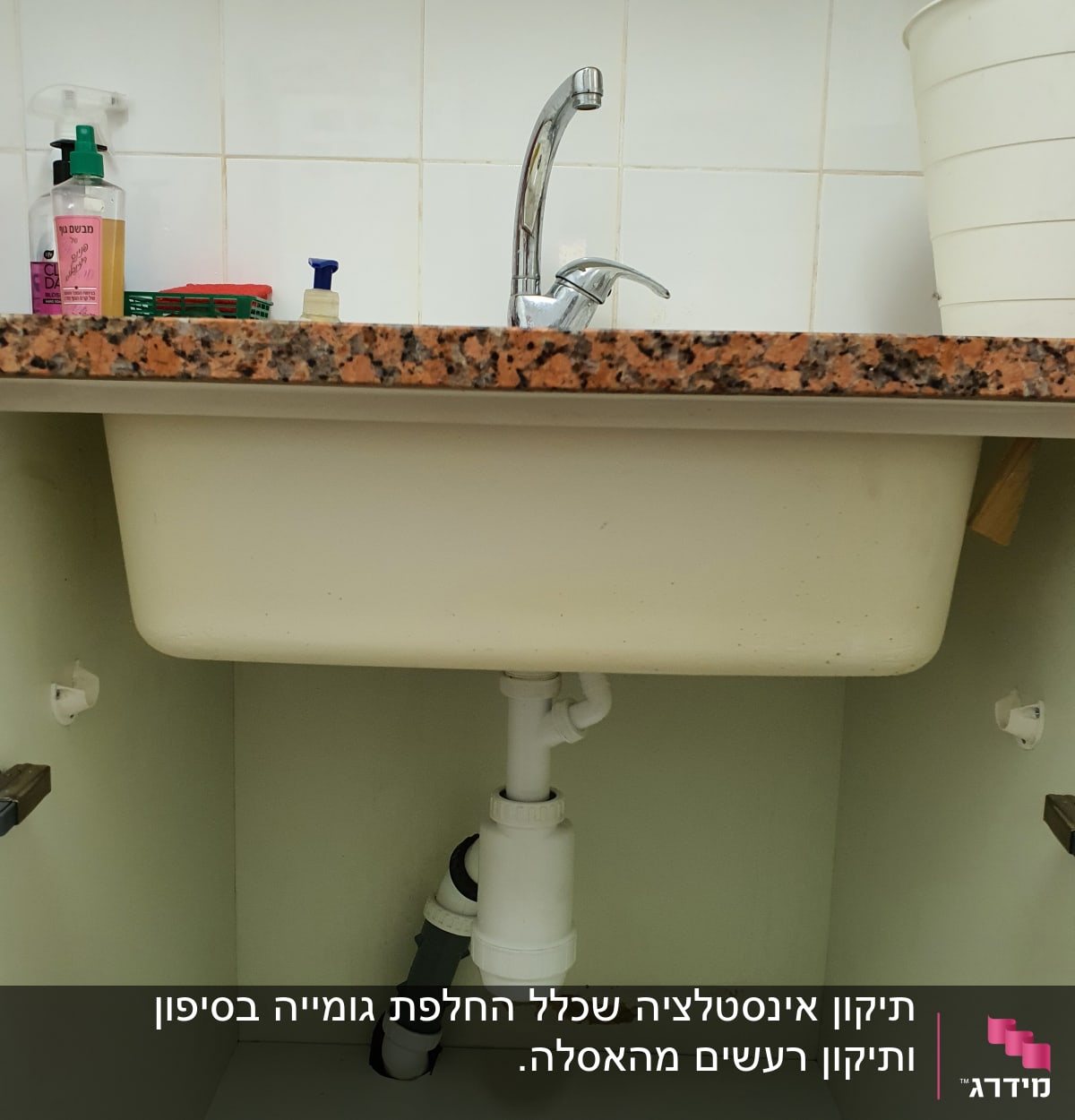 כיור עם ברז וצנרת מתחת לכיור